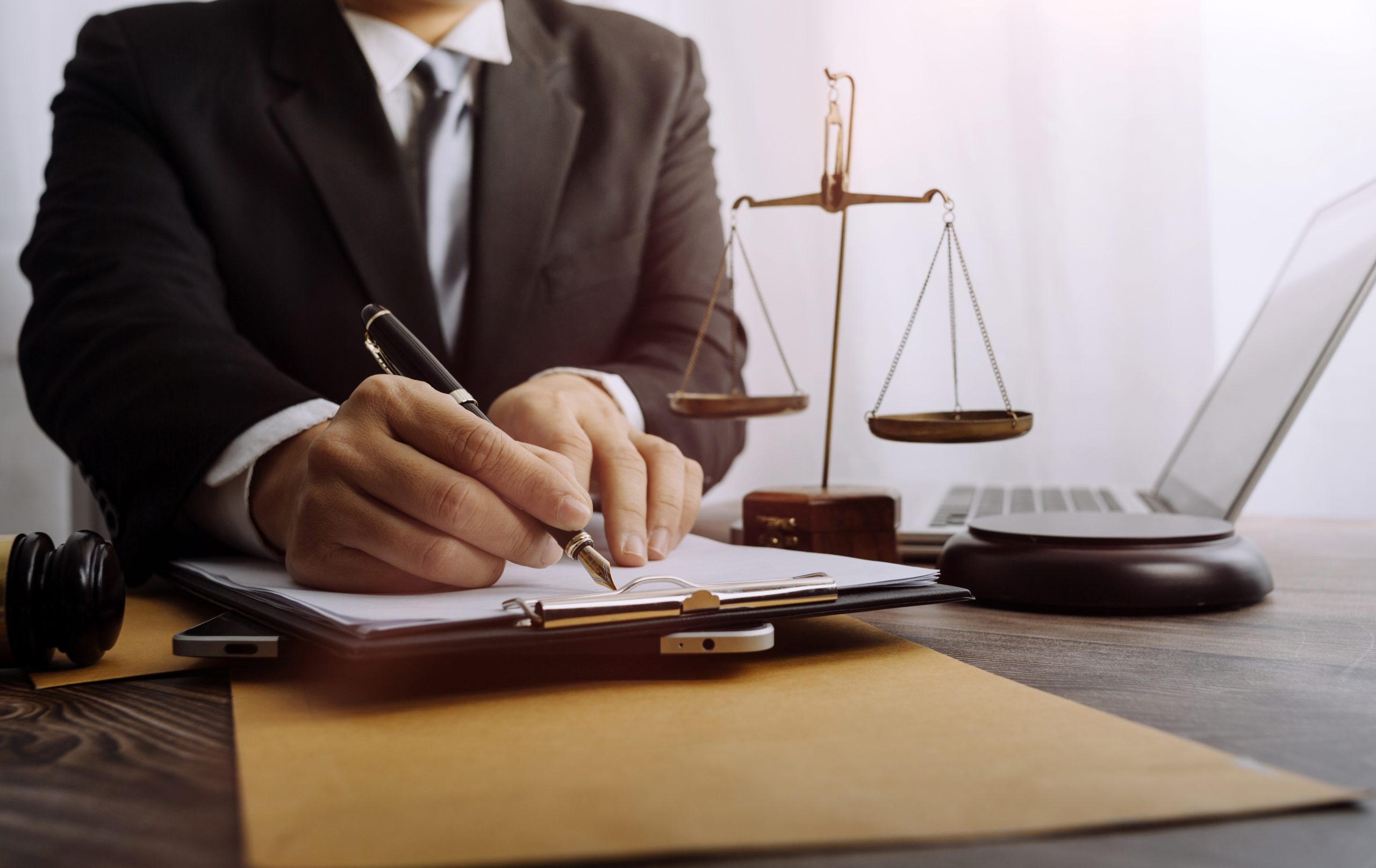 Judge in a courtroom working at a computer with a gavel on the desk